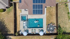 A rooftop swimming pool with a sun terrace, solar panels, and outdoor seating. - Hachie Hangout | Pool, Hot Tub, Pool Table, Fire Pit & Games (Waxahachie)