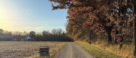 A gravel road with a sign indicating antiques and pottery.