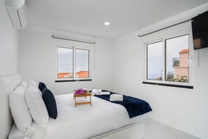 Ein Hotelzimmer mit einem Bett, einem kleinen Holztisch und zwei Fenstern.