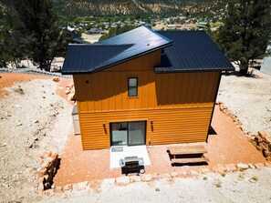 A two-story wooden house with a sloped roof, a front porch, and a small front yard. - Stargazing Dome Climbing Wall Zion & Bryce (Glendale)