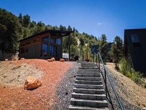 A modern building with a wooden exterior and a gravel pathway leading to a set of stairs. - Stargazing Dome Climbing Wall Zion & Bryce (Glendale)
