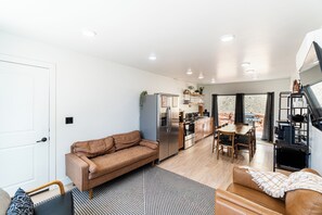 Un espace de vie moderne comprenant un canapé, une table à manger et un coin cuisine.