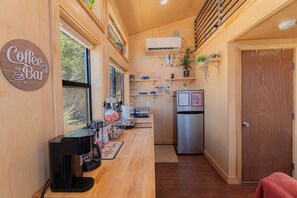 A compact kitchen with a coffee machine, a refrigerator, and a window with a view of trees. - Stargazing Dome Climbing Wall Zion & Bryce (Glendale)