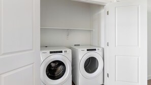A laundry room with two white Whirlpool washing machines. - Landing | Stylish 2BD, Pool, Gym (Dallas)