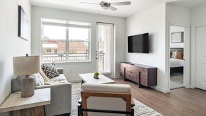 En moderne stue med sofa, sofabord, fjernsyn og spiseplads.