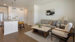 A modern living space with a kitchen, a dining area, and a seating area with a sofa and chairs. - Landing | Amazing 1BD, Courtyard, Clubhouse (Dallas)