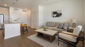 A modern living space with a kitchen, a dining area, and a seating area with a sofa and chairs. - Landing | Amazing 1BD, Courtyard, Clubhouse (Dallas)