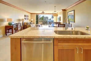 A spacious kitchen with a large island, wooden cabinets, and a view to the outdoors. - Hyatt Residence Club-Breathtaking 2 BR Beach-Front Villa!  Guaranteed Top Floors (Lahaina)