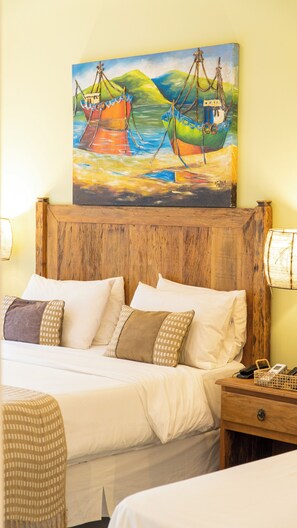A hotel room with a wooden headboard, a bed with white linens, multiple pillows, a bedside table with a lamp, and a painting of boats on a wall. - Pousada Montão Do Trigo (São Sebastião)