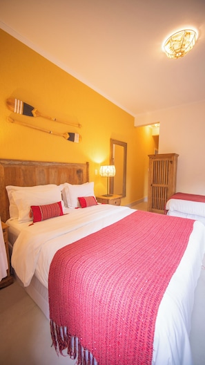 A hotel room with a large bed, a wooden headboard, a nightstand with a lamp, and a wardrobe. - Pousada Montão Do Trigo (São Sebastião)