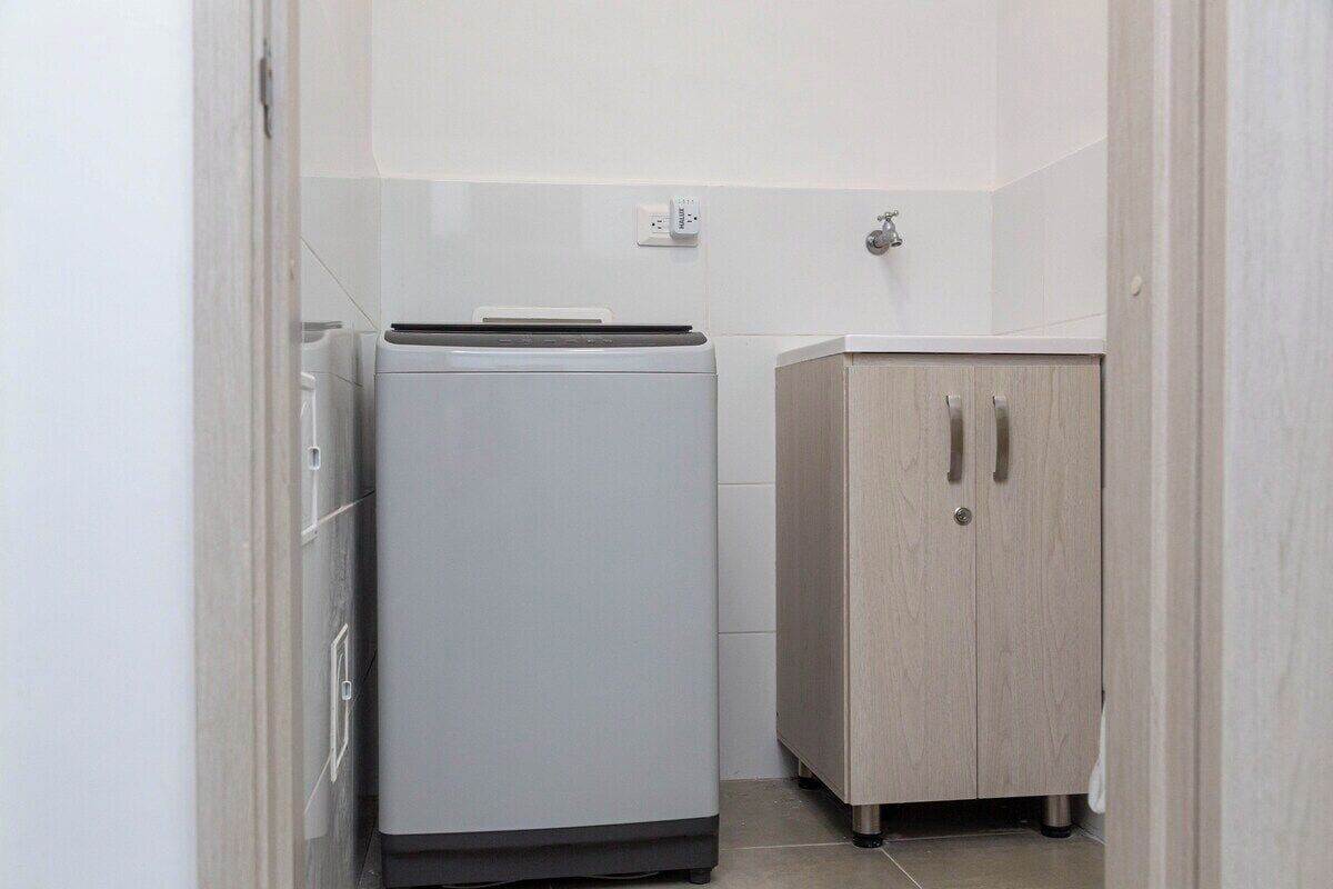 Ein kleiner Hauswirtschaftsraum mit Waschmaschine und Schrank.
