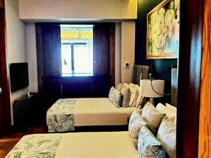 A room with a bed, a television, a window with curtains, and a painting on the wall. - Kingdom of the Sun, 2 BR/3 Baths for PGA Golf Tournament,Puerto Vallarta, Mexico (Puerto Vallarta)