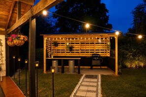 An outdoor patio area with a wooden pergola, string lights, and a barbecue grill. - A country home perfect for families, nature, and luxury, just 5 minutes from the airport (Antioquia)