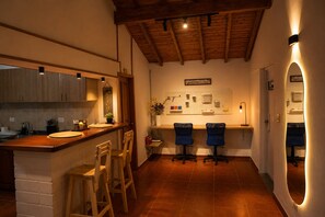 A kitchen with a wooden countertop, two bar stools, a wall-mounted pegboard, and a welcome sign. - A country home perfect for families, nature, and luxury, just 5 minutes from the airport (Antioquia)