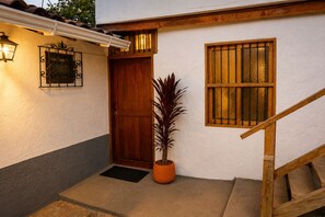 A wooden door, a potted plant, and a window with bars. - A country home perfect for families, nature, and luxury, just 5 minutes from the airport (Antioquia)
