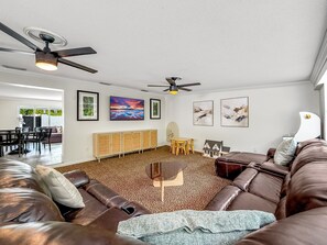 A living room with a brown leather couch, a small table, and a ceiling fan. - Exquisite Oasis Home! ~ Close To Beach & Shops! (Fort Lauderdale)
