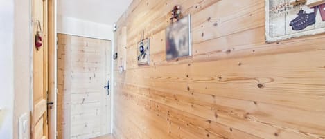 Un pasillo con paneles de madera y una puerta a la izquierda.