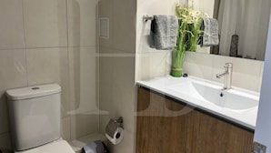 Ein Badezimmer mit Toilette, Waschbecken und Spiegel.