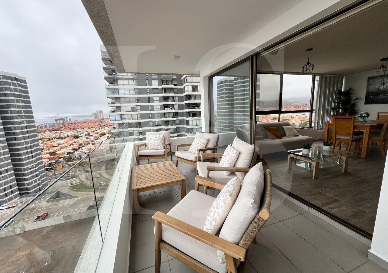 Un balcón con mobiliario exterior y vista a la ciudad.