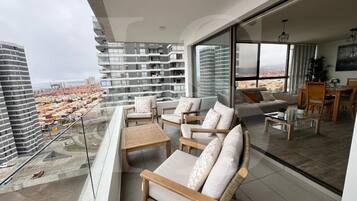 Un balcón con mobiliario exterior y vista a la ciudad.