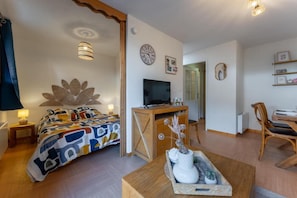 A bedroom with a bed, a desk, a television, and a dining area. - 20m from ski lifts, floor -1, swimming pool, sauna, terrace, tv, ski locker, 34m², Les Orres (Les Orres)