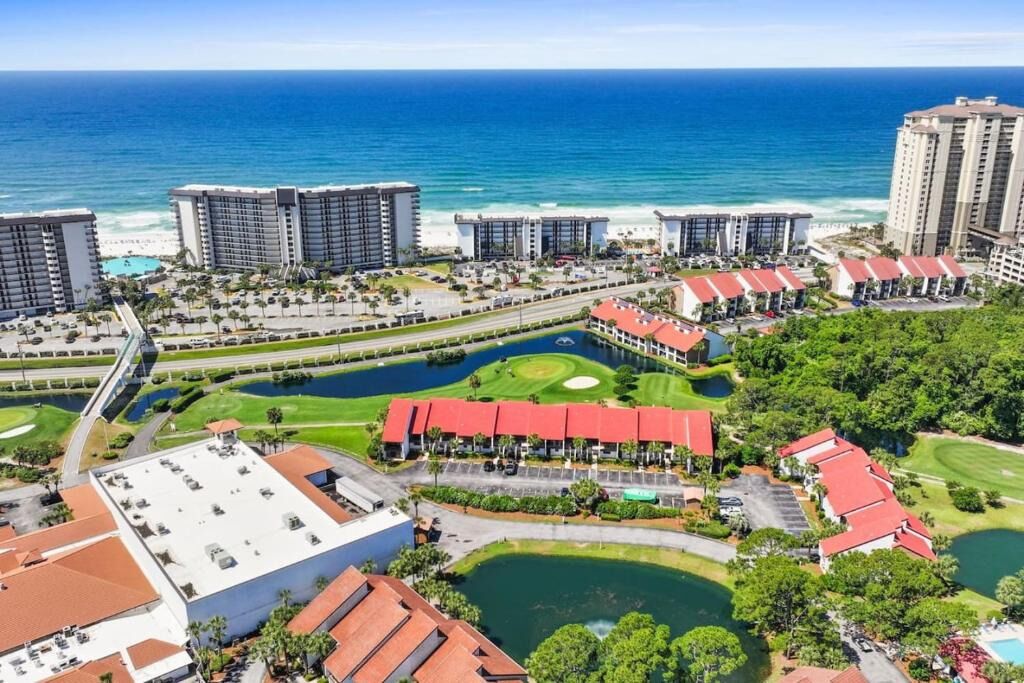 A coastal resort with multiple high-rise buildings, a golf course, and a marina.