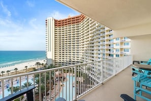 A high-rise hotel with a pool area and a view of the beach. - Shores Of Panama (Panama City Beach)