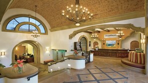 Un'ampia hall con reception, lampadari e una grande finestra.