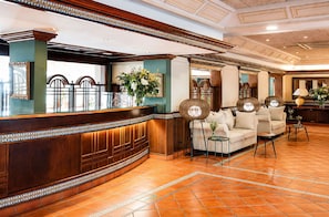 A reception area with a wooden reception desk, a sofa, and a coffee table.
