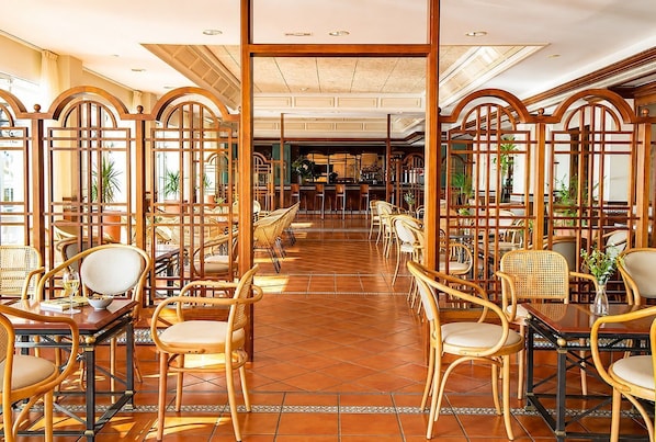 A restaurant with wooden furniture and a tiled floor.