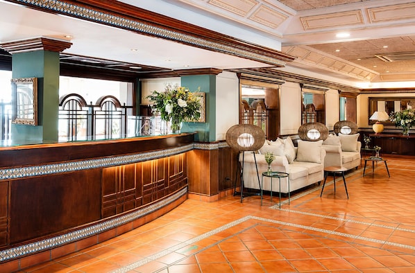 A reception area with a wooden reception desk, a sofa, and a coffee table.