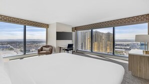 Une chambre d’hôtel moderne équipée d’un grand lit, d’un bureau, d’une chaise et d’un téléviseur.