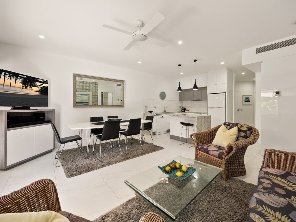 A modern living space with a dining area, kitchen, and seating area.