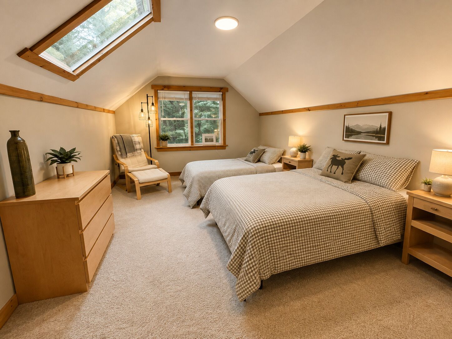 Une chambre avec deux lits, un bureau, une chaise, une fenêtre donnant sur les arbres et un puits de lumière.