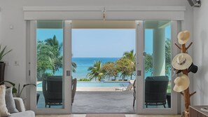 A room with a view of the ocean, a pool, and a hat rack with hats. - Luxury Villa Sol y Mar in Vieques (Vieques Island)