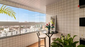 Eine moderne Wohnung mit Balkon, einem Essbereich mit Tisch und Stühlen sowie Blick auf die Stadt.
