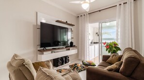 Ein modernes Wohnzimmer mit Flachbildfernseher, einer Couch und einem Couchtisch.