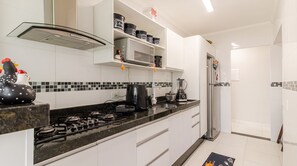 Eine moderne Küche mit Gasherd, Mikrowelle und Kühlschrank.