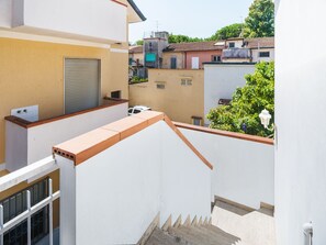 A residential building with a white exterior, a garage door, and a small balcony with a metal railing. - La Casa di Margot by Interhome (Viareggio)