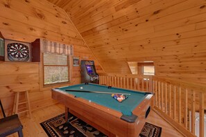 A pool table in a wooden room with a dartboard and a pinball machine. - A Beary Special Place | Hot Tub | Game Loft (Sevierville)