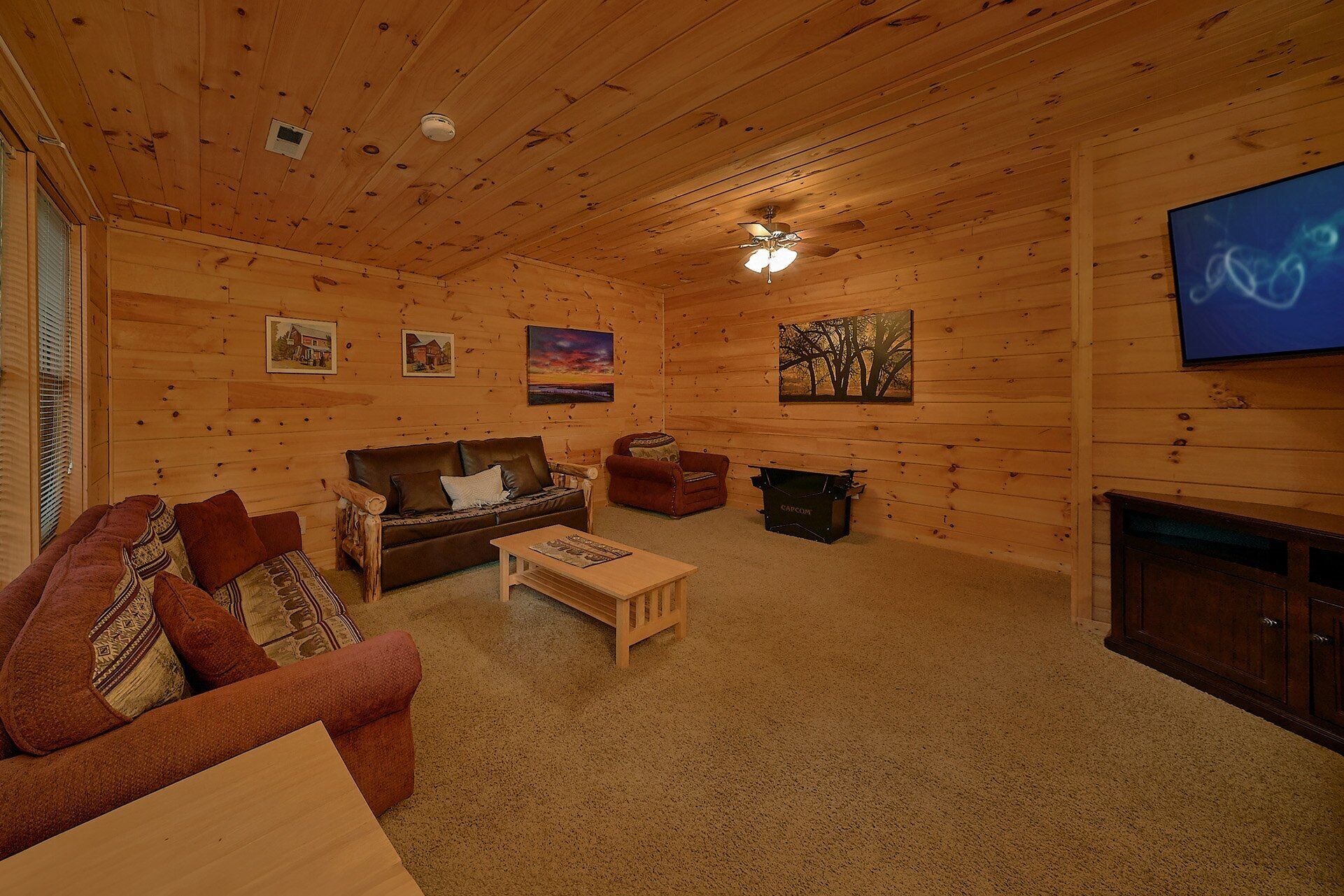 Interior acogedor de una cabaña de madera con sofá, sillón y chimenea.