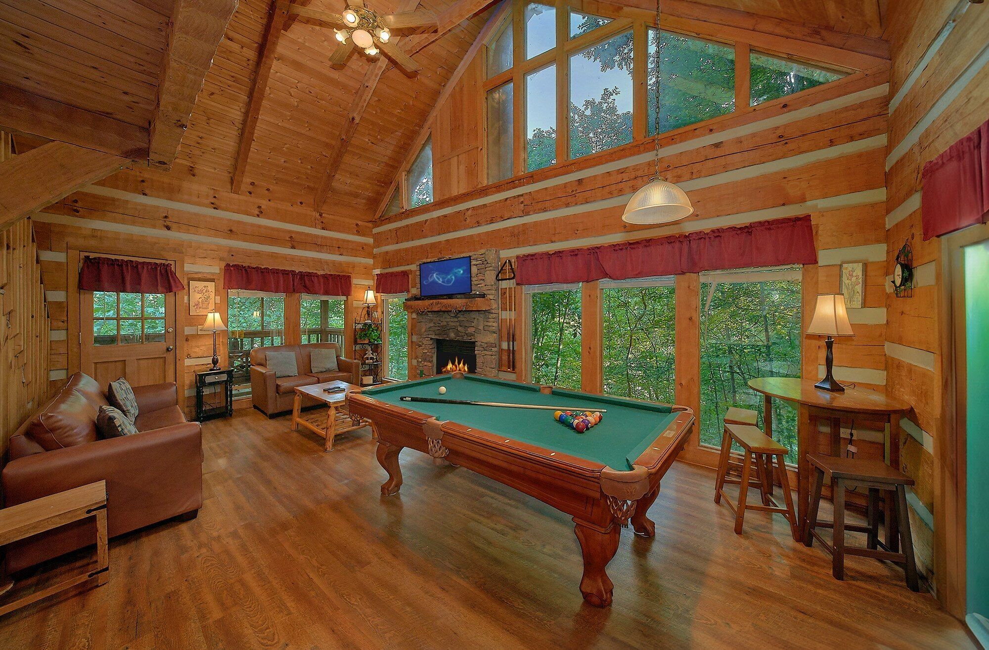 Une pièce spacieuse équipée d’une table de billard, de sièges confortables et de grandes fenêtres donnant sur l’extérieur.
