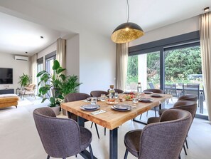 A modern dining area with a wooden table set for six, surrounded by dark chairs. - Vacation home Riata by Interhome (Poreč)