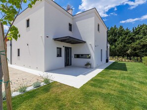 A modern two-story house with a flat roof, a covered patio, and a well-maintained lawn. - Vacation home Riata by Interhome (Poreč)