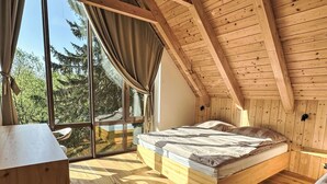 A bedroom with a wooden ceiling, a large window, and a bed. - Rebelka by Interhome (Horni Misecky)