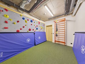 Un rocòdrom amb parets acolxides, una paret d'escalada i una barra per fer flexions.
