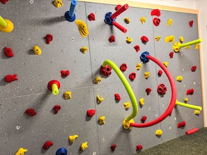 Eine Kletterwand mit verschiedenen Griffen und einem Seil.