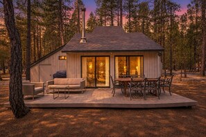 A cabin with a deck, a fireplace, and a dining area. - Trail One | Black Butte Ranch | Sleeps 8 | Family (Sisters)