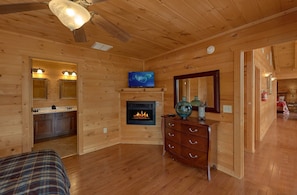 Un intérieur en bois avec une cheminée, un téléviseur et un miroir.