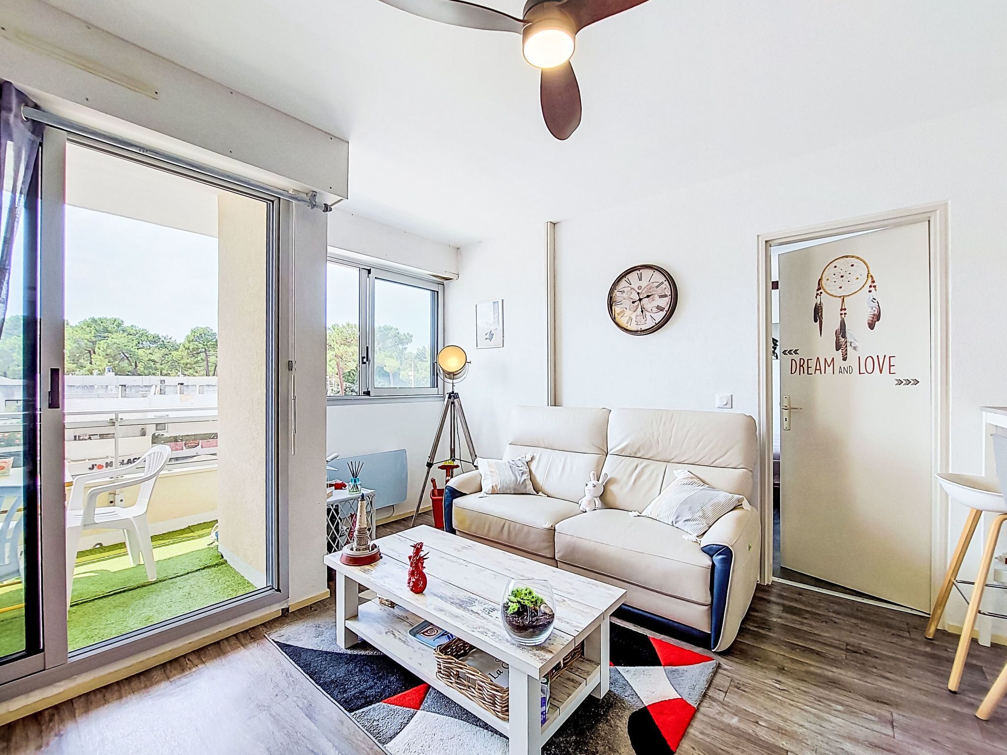 Un salon moderne avec un canapé, une table basse et un ventilateur de plafond.
